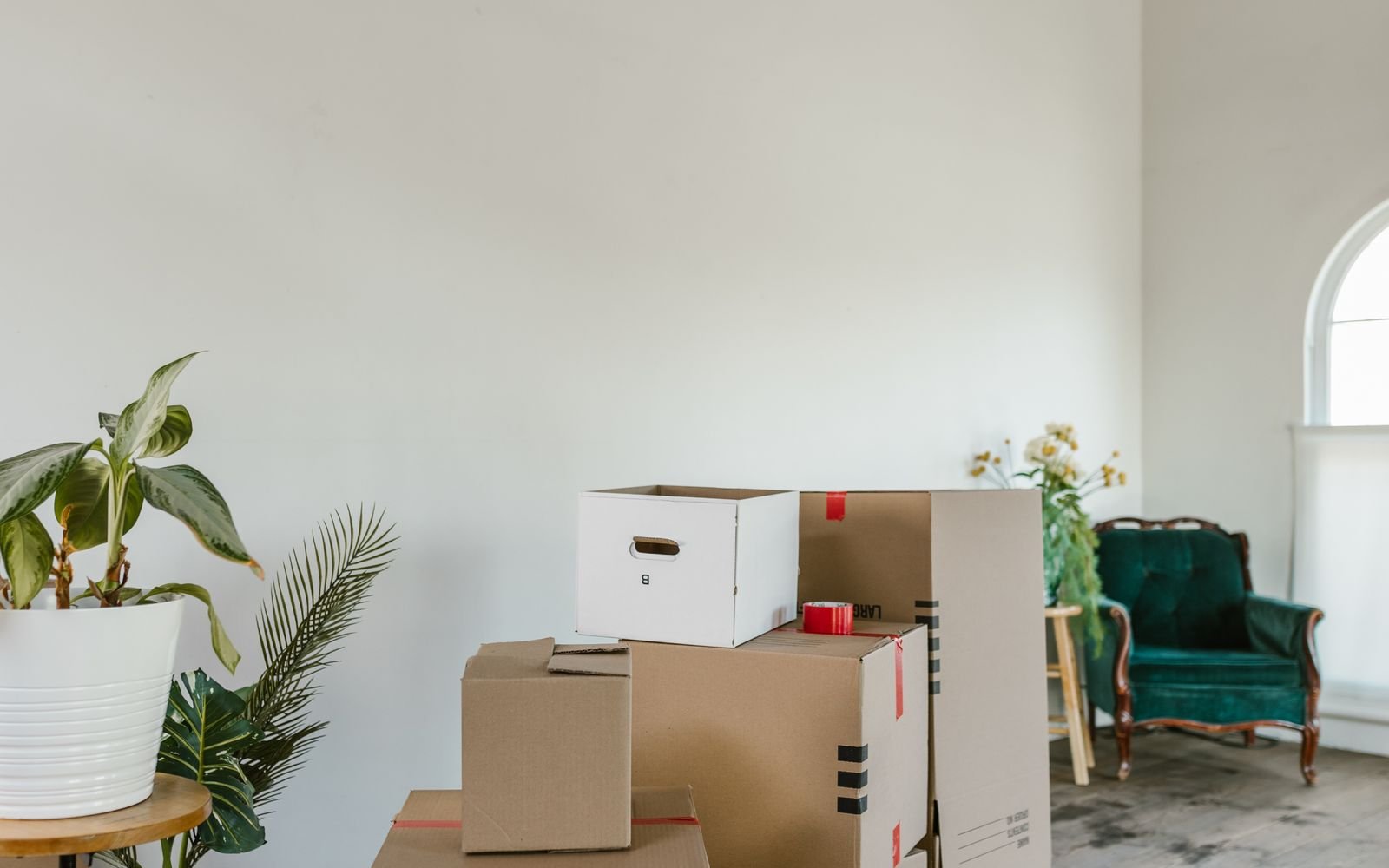 Cartons de déménagement empilés sur un parquet dans une pièce lumineuse